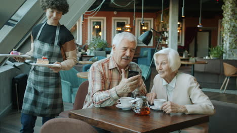 elderly couple enjoying dessert at cafe