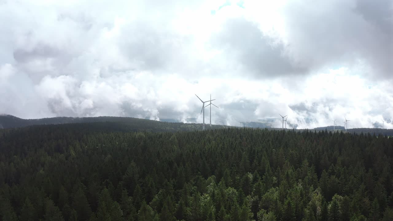 Lush green forest landscape with wind turbines on the horizon, Norway