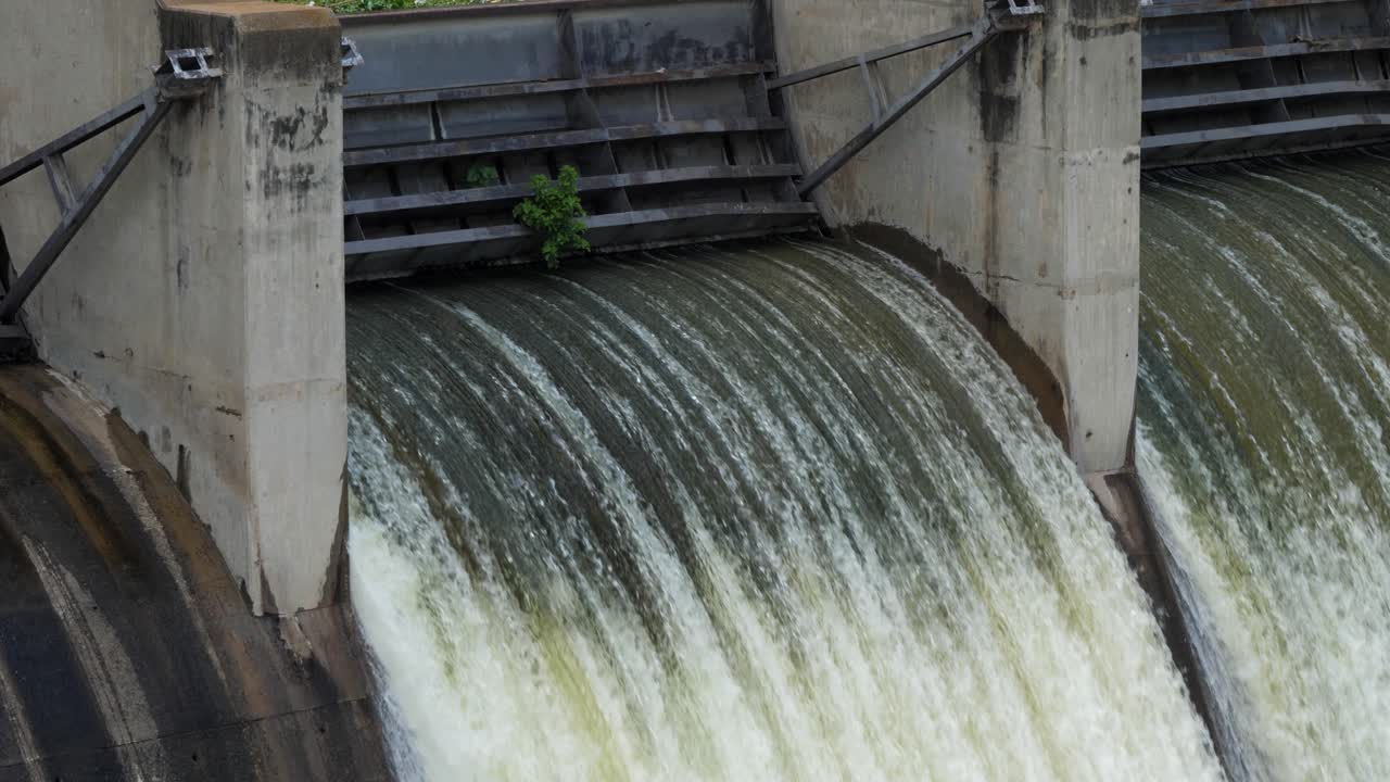 Slo Mo tilt down sluice gate on hydro dam as water pours through