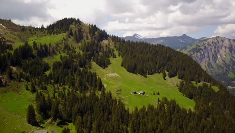 view of a small mountain in the swiss alps with a chalet on it