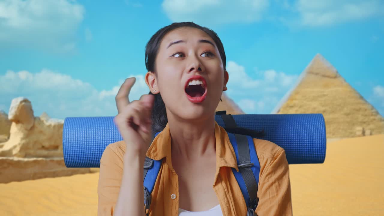 Close Up Of Asian Female Hiker With Mountaineering Backpack Thinking About Something And Looking Around Then Raising Her Index Finger While Traveling In Pyramid Of Giza