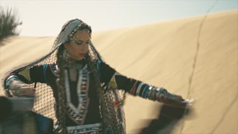 gypsy woman dancing and waving her dress in the desert