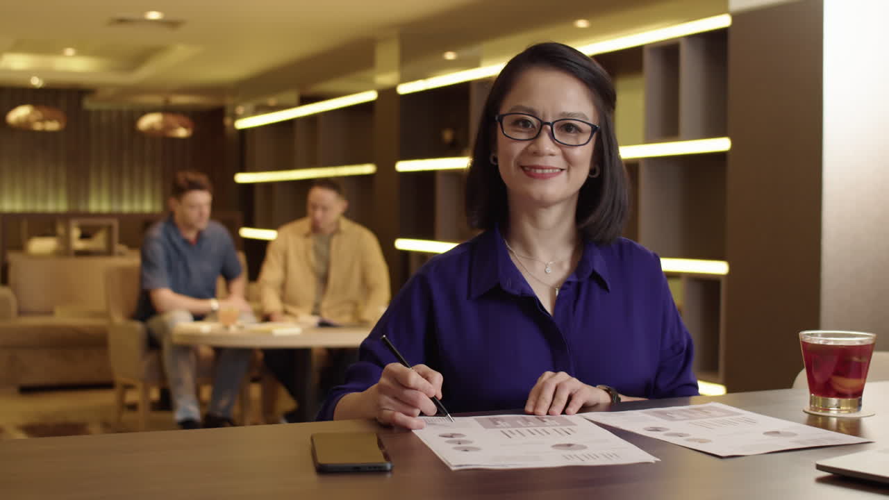 Cheerful female Entrepreneur Signing Agreement at Hotel Lounge