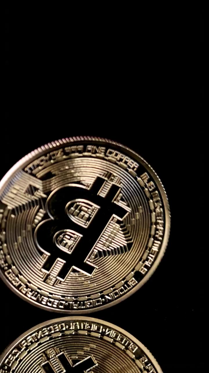 Moedas de criptomoeda douradas giram e caem em uma superfície preta brilhante com iluminação dramática