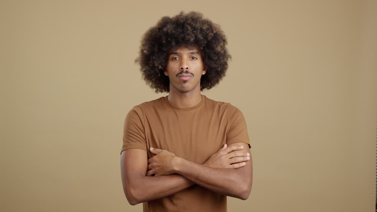 Man with Afro Hair and Mustache Standing with Arms Crossed