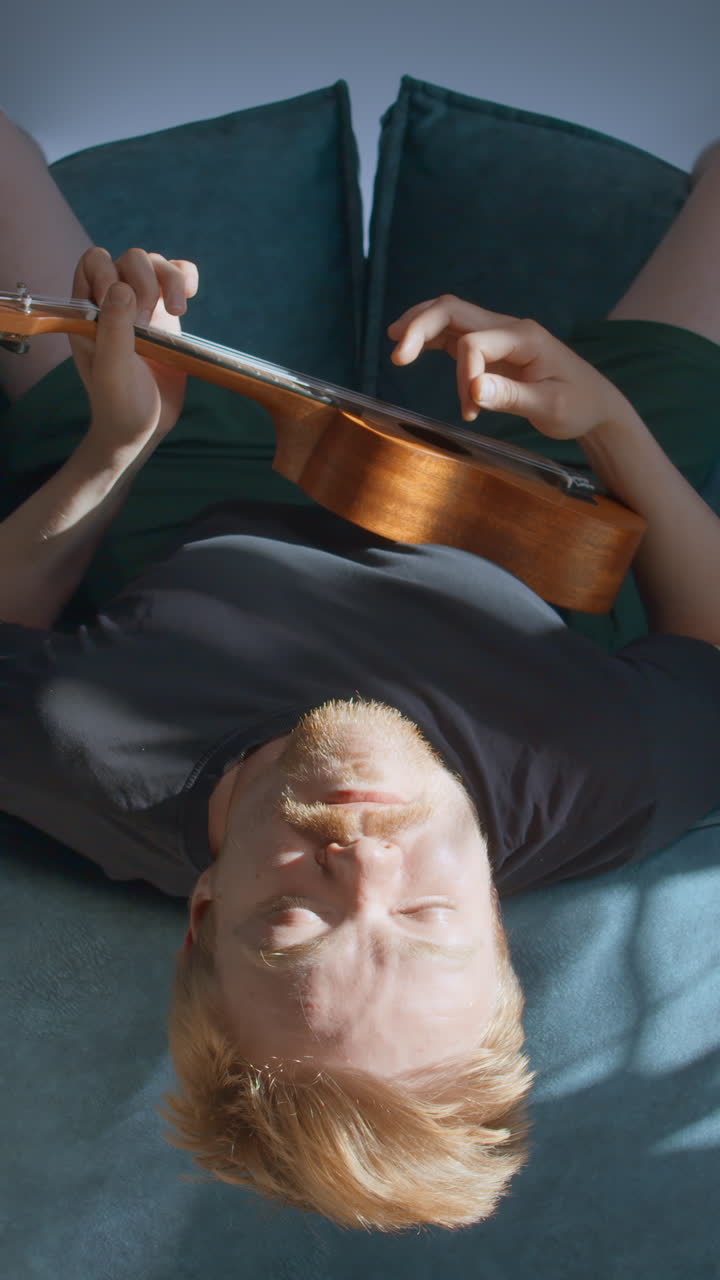 Hombre tocando ukelele acostado