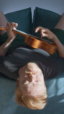 Man Playing Ukulele Lying Down