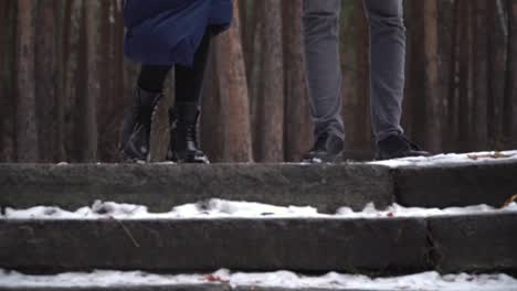 couple walking on snowy steps in a forest