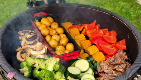 smoking meat, corn, peppers, mushrooms, broccoli, potatoes, and squash on an outdoor grill