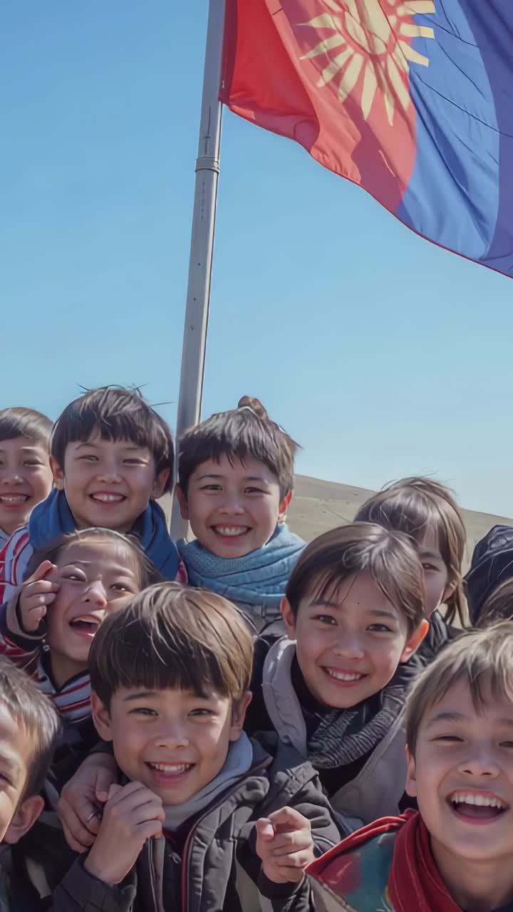 Vertical video: Reacting to cue, kids posing at pole on hill, flags waving, in jackets and scarves