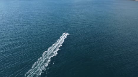 following a small boat as it speeds through the open ocean