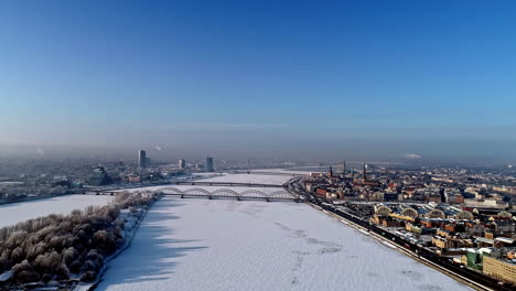 aerial view over frozen daugava river in winter, snowy riga city