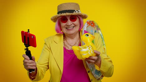 blogger viajero abuela madura con gafas de sol, tomando selfies en el teléfono móvil, llamada de video en línea
