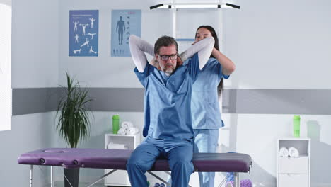 physical therapist assisting patient with arm exercises