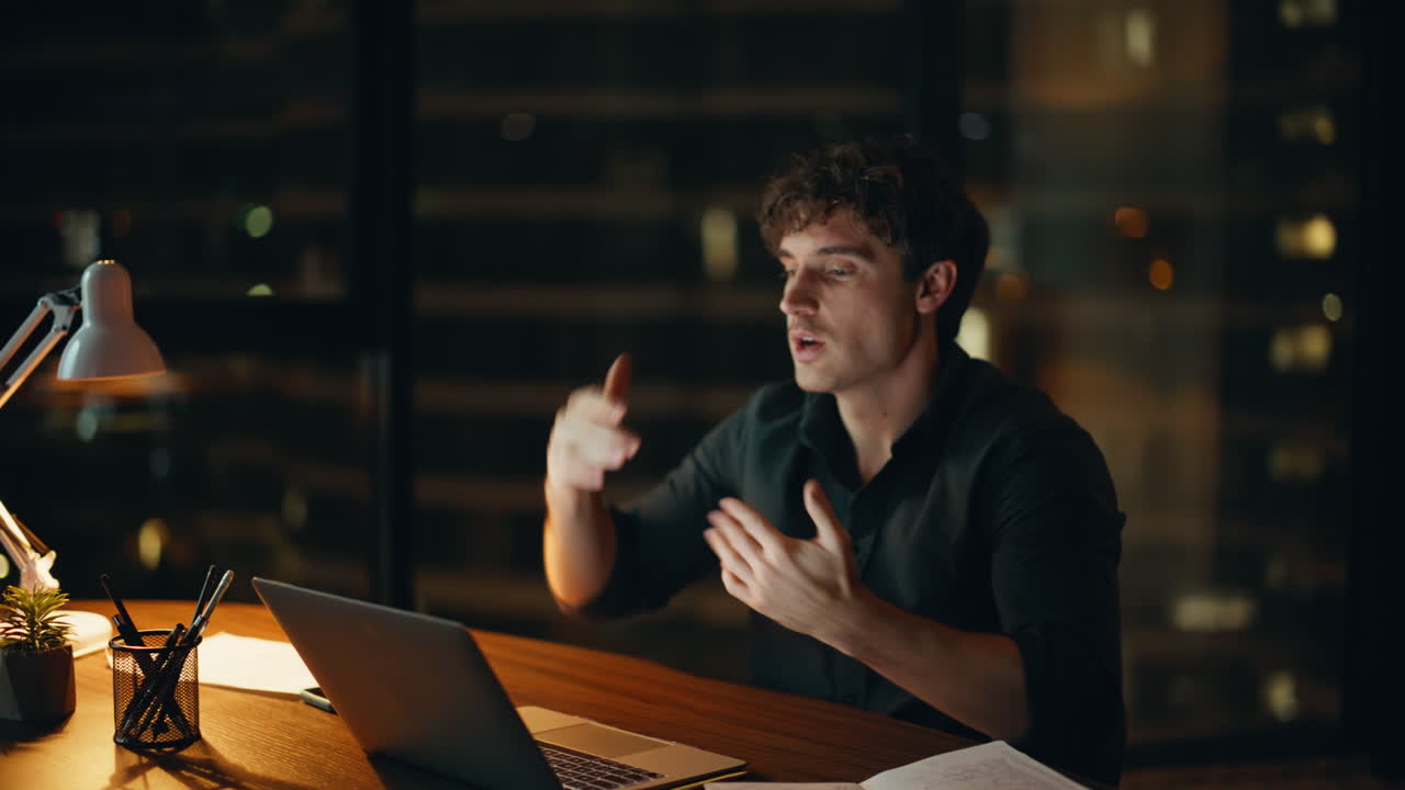 Primo piano di un business coach che parla in videoconferenza in un ufficio notturno. Uomo che fa una presentazione
