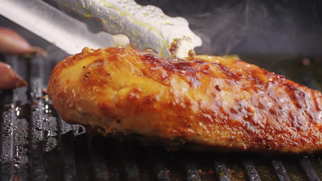 Cooking raw chicken meat in yellow turmeric spice with garlic and greens on grill close-up. Fry chicken slice on frying.pan Grilled chicken, duck, turkey kebab with vegetables.