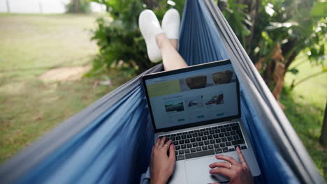 working on a laptop in a hammock