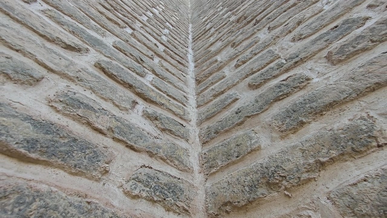 Vista dal basso dell'angolo di un antico muro di pietra