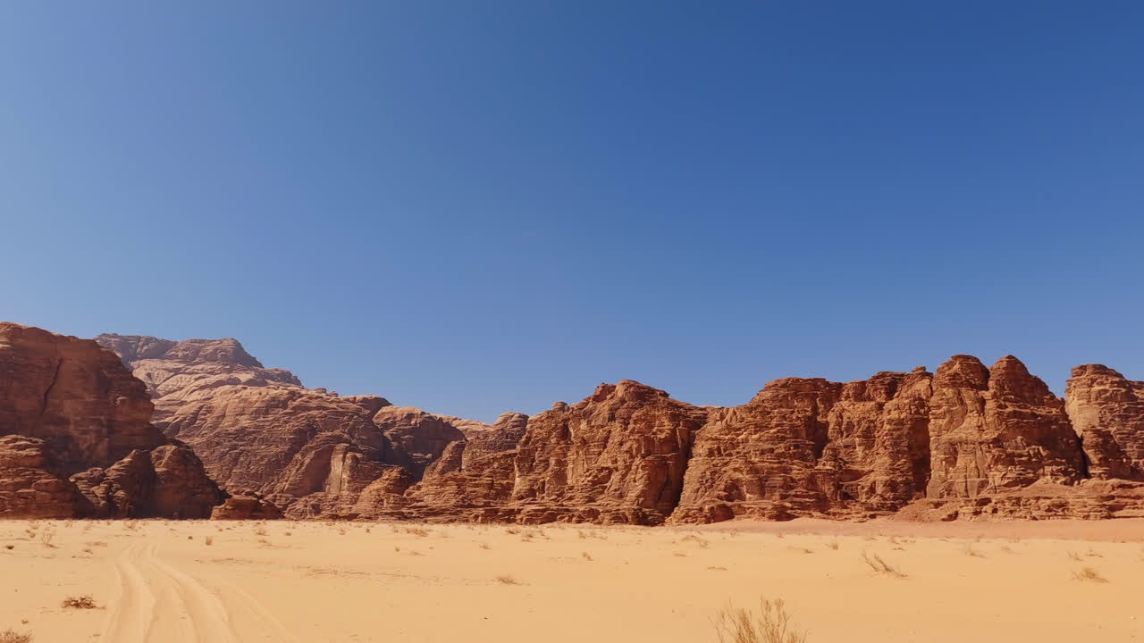 Panoramica sulla valle del fiume Wadi Rum con cielo azzurro brillante nel deserto