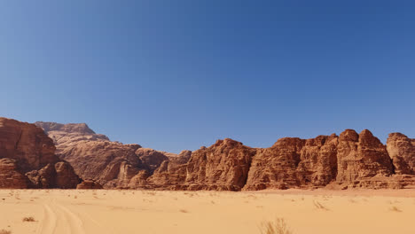 pan across wadi rum river valley vista with bright blue sky in the desert