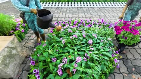 statues of gardeners among vibrant flowers