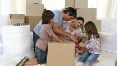 padres e hijos mudándose de casa empacando cajas
