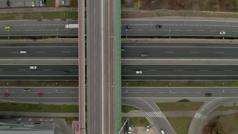 aerial slowly ascending drone footage of a highway full of moving cars.