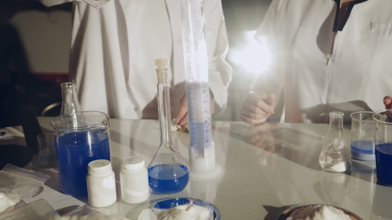 Scientist working with chemical reaction in chemistry lab. Chemical reaction in glass flask. Lab worker doing chemical experiment in laboratory