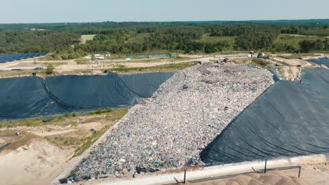 open-air landfill site for non-recyclable waste, shot by drone in summer