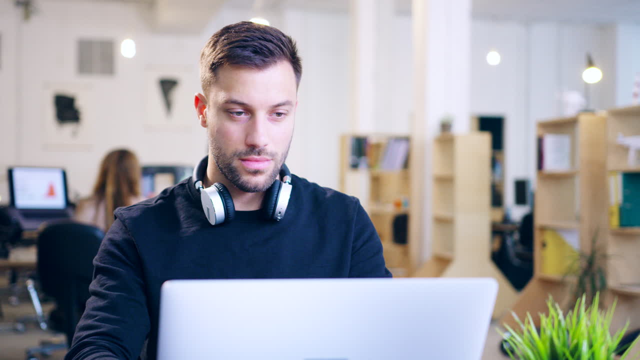 Ein Mann arbeitet an einem Laptop in einem modernen Büro