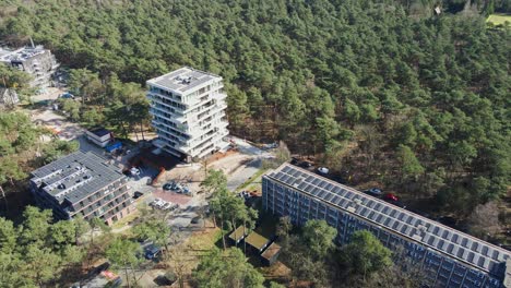 tilt down of beautiful apartment buildings surrounded by a green forest