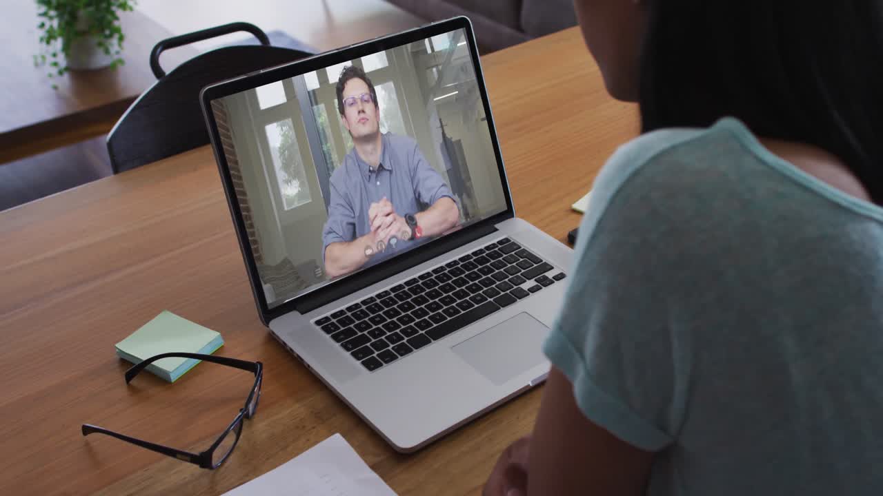 Mid section of african american woman having a video call with male colleague on laptop