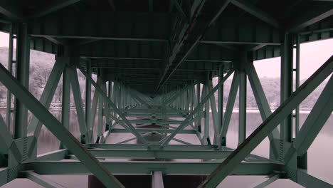 fly-underneath-green-bridge-and-over-water