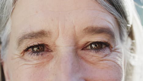 portrait of close up of eyes of happy unaltered senior caucasian woman, in slow motion