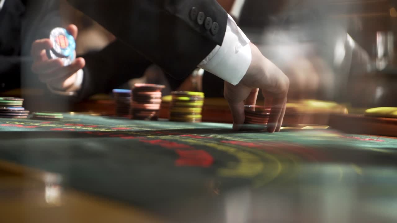 Slow motion close up shot of croupier laying out poker chips on casino table