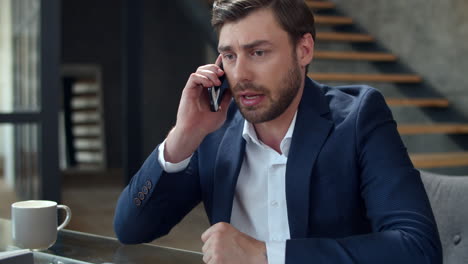 Angry-businessman-talking-on-the-phone-at-home-office