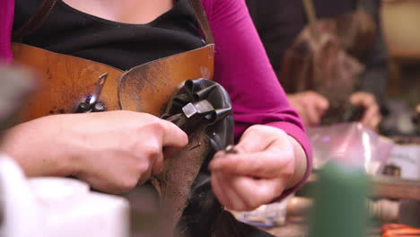 bespoke shoemaker pinning leather together to make shoe