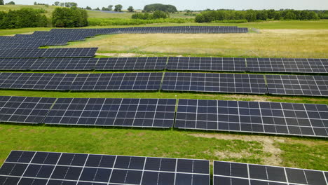 solar power station panels close-up in the middle of green field, aerial flyover low angle poland, low altitude