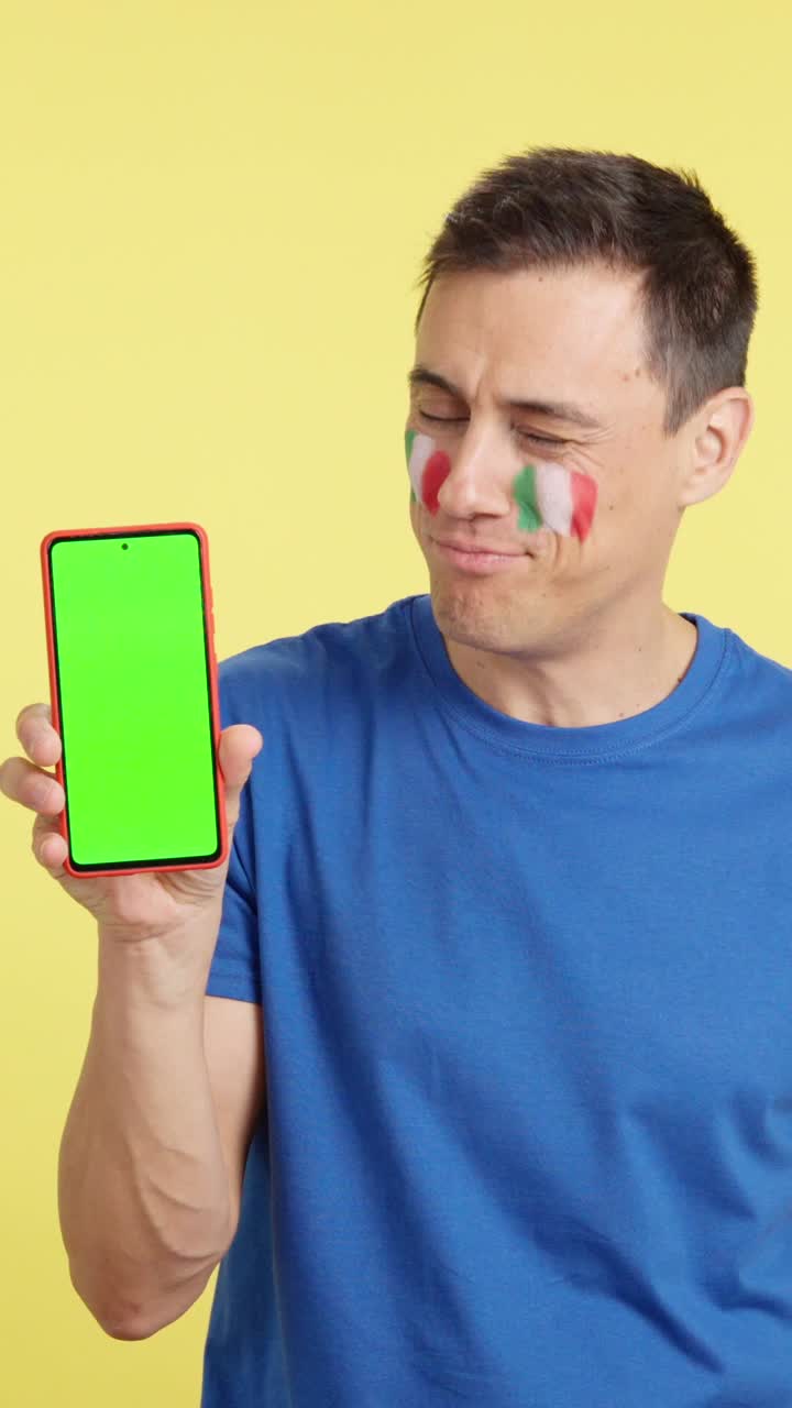 Italian man looking at his mobile smiling and showing it