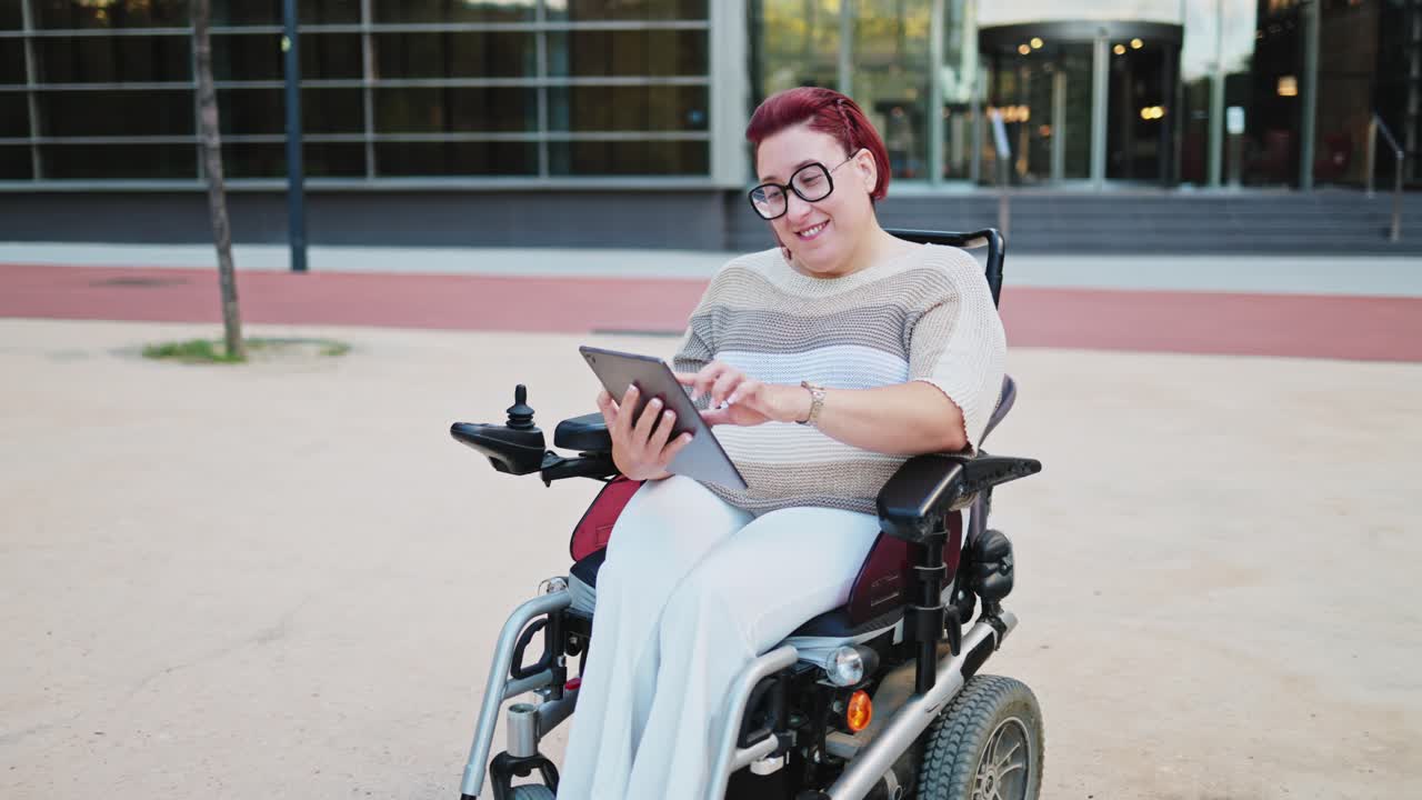 Mulher Feliz em Cadeira de Rodas Elétrica Usando Tablet ao Ar Livre