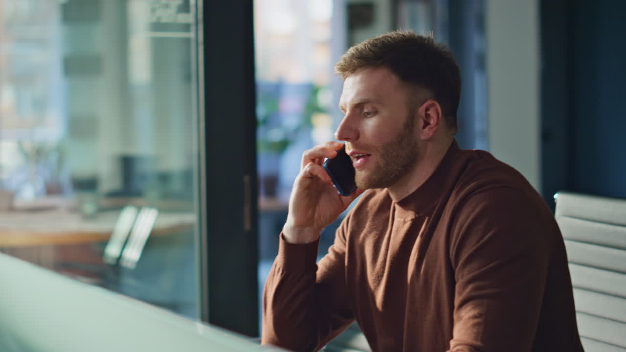 Pensive manager answering cellphone call working at office closeup. Smiling man