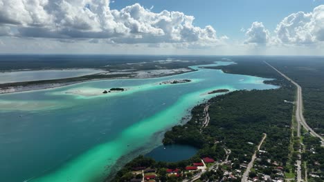 Aerial-view-of-the-Cenote-Negro-and-the-colorful-shades-of-the-Bacalar-lagoon,-in-Mexico