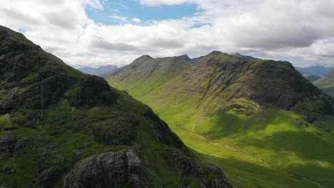 Aerial-shot-in-Scotland-of-mountains-and-valley-in-Glencoe-mountain-range-in-the-Highlands-of-Scotland-on-a-sunny-summer-day