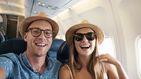 happy couple taking selfie on airplane