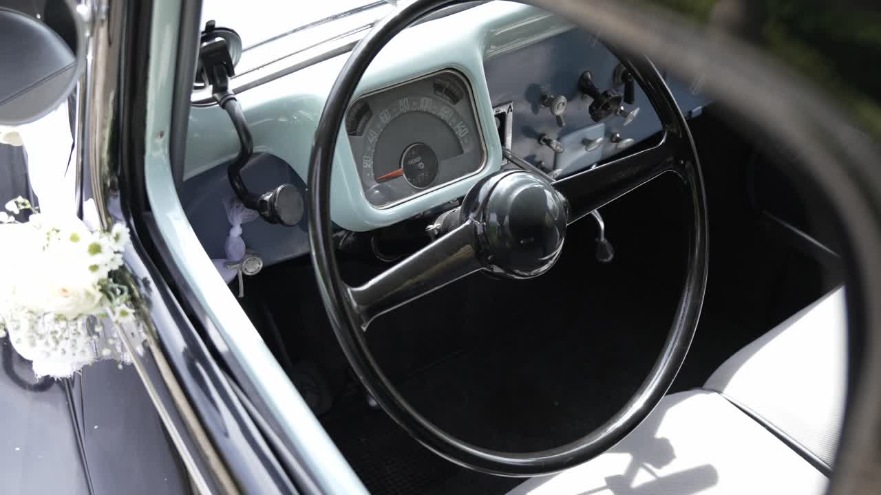 Close up of a vintage wedding car's interior with a retro steering wheel