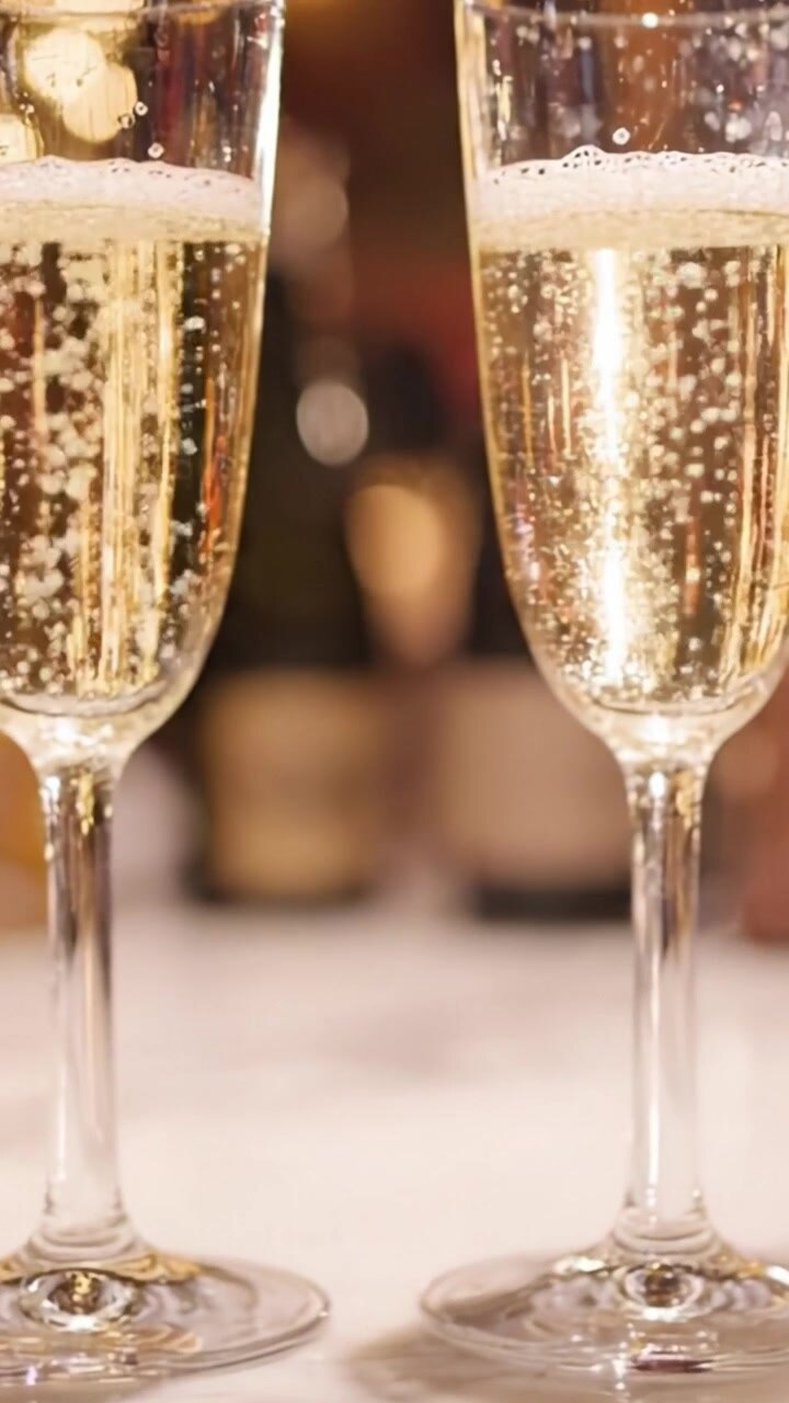 Brindisi alle celebrazioni: un primo piano accattivante di calici di champagne scintillanti, bollicine che salgono in gioia effervescente e brindisi a momenti condivisi con i propri cari.