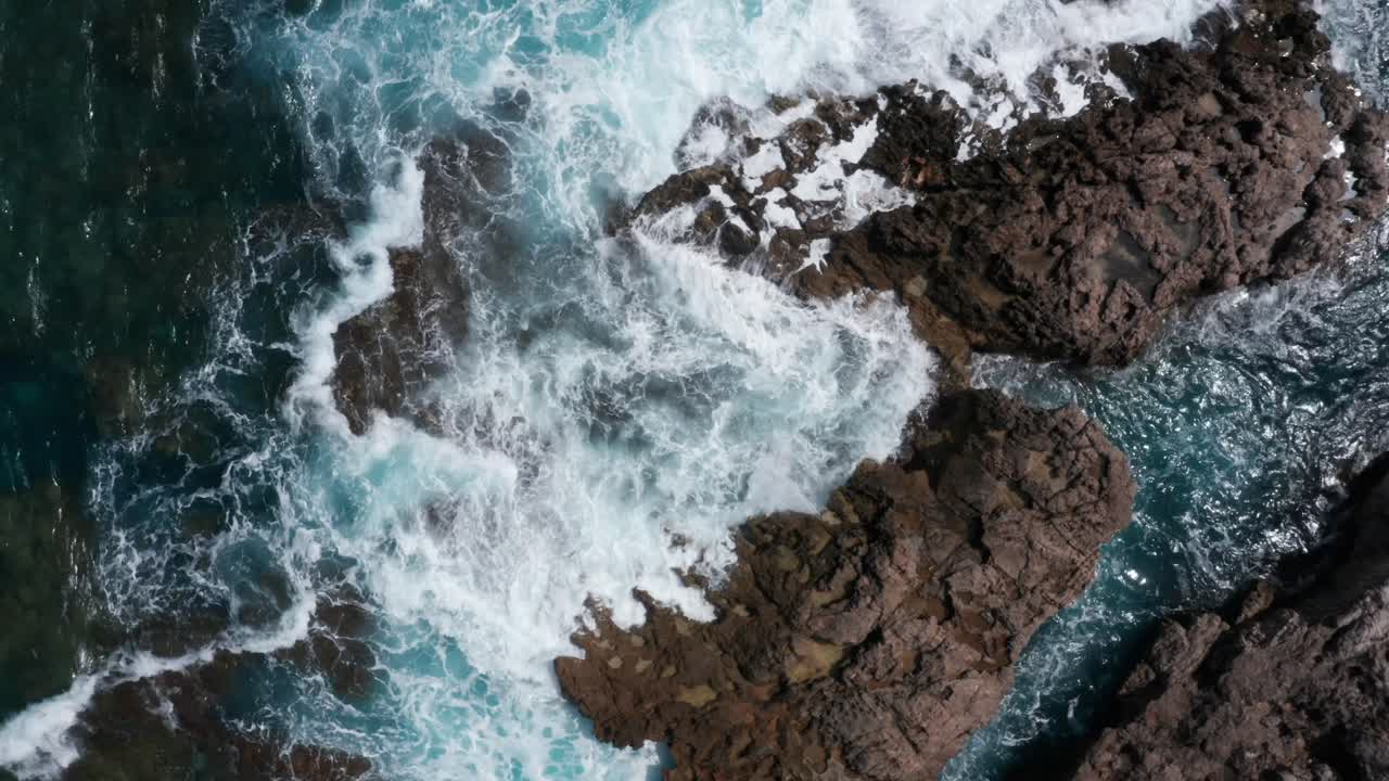 Onde che si infrangono sulla costa rocciosa dell'isola di Maiorca con acqua blu