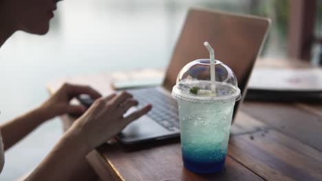 young female remote worker drinking an ice cold sugary drink to stay awake and focused