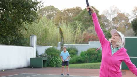 mujer mayor jugando al tenis en la cancha de tenis 4k