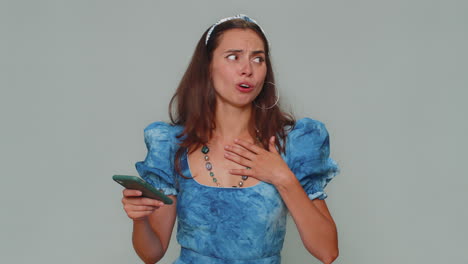 mujer joven triste uso de teléfono inteligente, pierde ser sorprendido resultados repentinos de la lotería, mala fortuna, pérdida